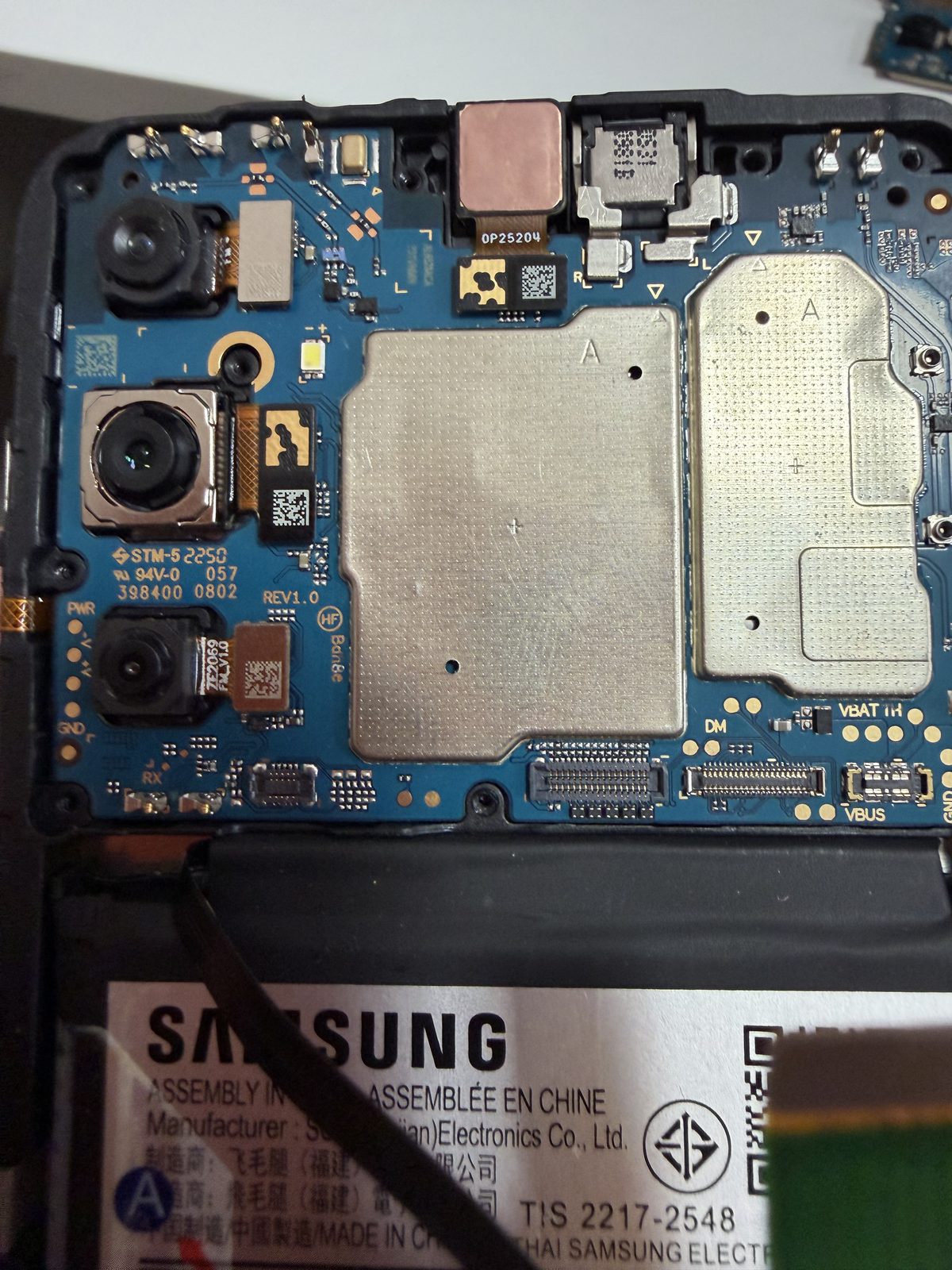 Carte mère Samsung Galaxy ouverte en atelier Solution Phone Mâcon — caméras et composants internes